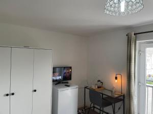 Zimmer mit einem Schreibtisch und einem TV an der Wand in der Unterkunft Luxury Large Beds in West Thurrock 3 bathrooms 1 en suite Netflix Free Parking in Grays Thurrock