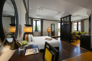 Habitación de hotel con cama y comedor en Silkian Hoian Boutique Hotel & Spa, en Hoi An