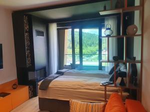 1 dormitorio con cama y ventana grande en NA STAZI-Luxury Mountain- on the ski slope-Free parking,Tuzlaks apartment en Bjelašnica