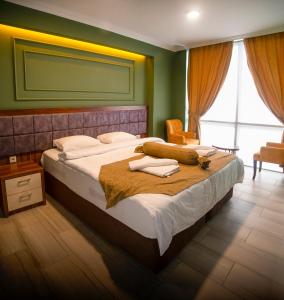 トラブゾンにあるTRABZON Asel Suite Otelのベッドルーム1室(大型ベッド1台、タオル付)