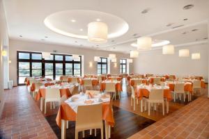 una sala da pranzo con tavoli, sedie e finestre di Meteora Hotel at Kastraki a Kalabaka