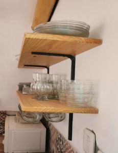 uma prateleira com pratos e tigelas na parede em Sonko em Tafí del Valle