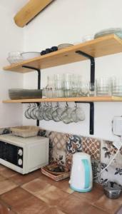 una cocina con una estantería sobre un microondas en Sonko en Tafí del Valle