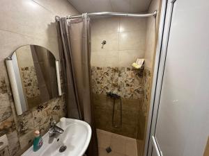 een badkamer met een douche en een wastafel bij STEPROOMS in Tbilisi City