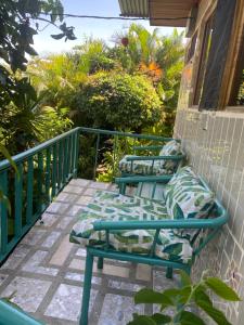 un porche con 2 sillas en el balcón en Owl House en Piedades