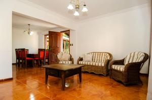 a living room with two chairs and a coffee table at Casa com Piscina para 12 hóspedes, 7 minutos da Praia no Campeche HY3097 in Florianópolis
