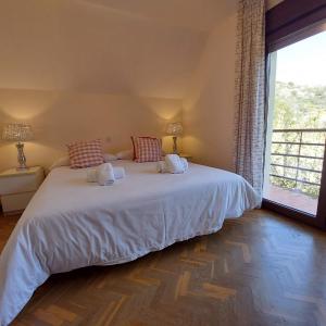 a bedroom with a white bed with a large window at Puente Canto de Gredos in Arenas de San Pedro