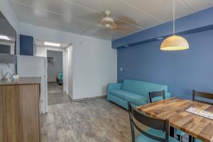 a living room with a table and a blue couch at Le Voyageur - a Red Collection Hotel in Wildwood