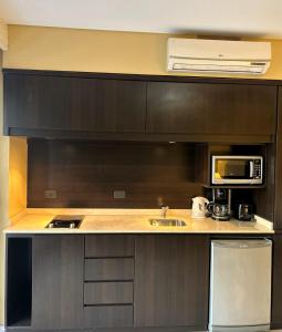 a kitchen with a sink and a microwave at Comfortable Modern Apartment in Buenos Aires +3 photos