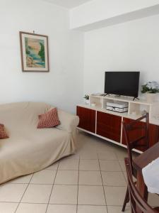 sypialnia z łóżkiem i telewizorem na szafce w obiekcie Casetta Eva w mieście Anacapri
