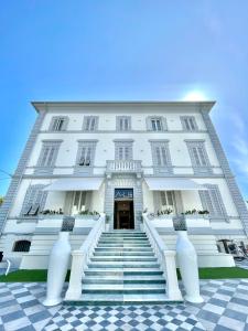 un edificio bianco con scale di fronte di Hotel Tirreno a Marina di Massa