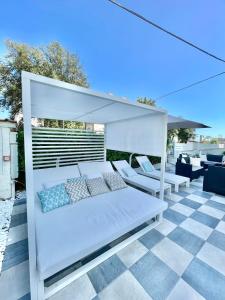 a white bed with pillows on a patio at Hotel Tirreno in Marina di Massa