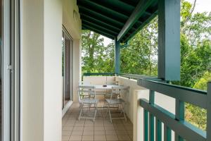 un balcón con mesa y sillas. en Ziburu Mendi - Appartement Calme, Vue Mer, Parking - WiFi, en Ciboure