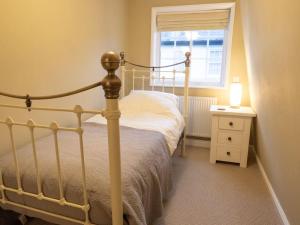 um quarto com uma cama e um candeeiro numa mesa de cabeceira em The Old Reading Rooms Linton em Linton