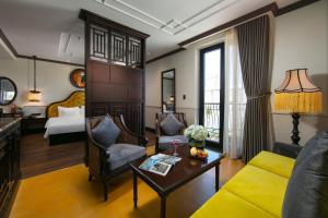 een woonkamer met een bank en een bed bij Silkian Hoian Boutique Hotel & Spa in Hội An