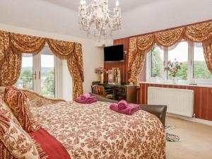 a bedroom with a bed with purple pillows on it at Storrs Lodge in Windermere