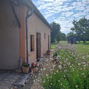 uma casa com flores em frente a um edifício em Chambres d hotes proche Macon em Grièges