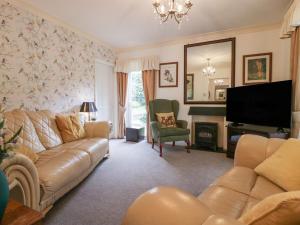 a living room with a couch and a television at The Bird's Nest in Windermere