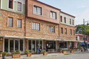 a large brick building with people sitting outside of it at Meydani Otel in Gokceada Town