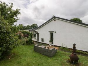 a white house with a yard with a bench at The Bird's Nest in Windermere