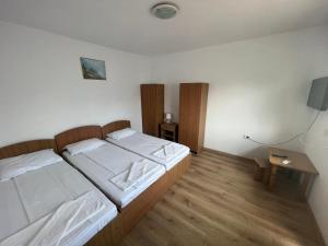 ein Schlafzimmer mit zwei Betten und einem Fernseher in der Unterkunft Mario Residence in Costinești