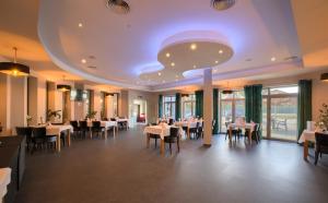 a restaurant with tables and chairs and a large ceiling at Nova Stodola in Kłomnice