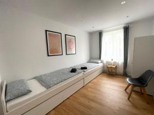 een kamer met 2 bedden en een stoel. bij 70qm - 3 rooms - free parking - city - MalliBase Apartments in Hannover