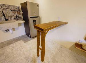 Cette chambre comprend une table en bois et un réfrigérateur. dans l'établissement Estudio#1 Mi pequeño jardín, à Cancún
