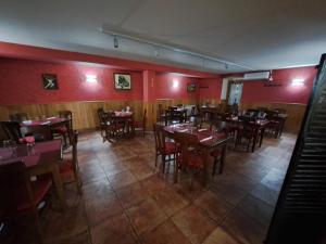 Posada de Oitz في Oiz: غرفة طعام بطاولات وكراسي وبيانو