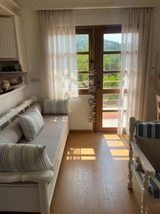 um quarto com uma cama, uma janela e uma porta em Coralina Cottage em Koríthion