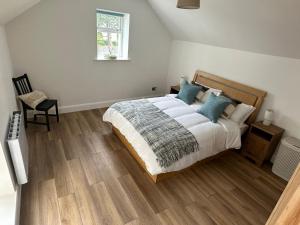 - une chambre avec un lit doté d'oreillers bleus et d'une fenêtre dans l'établissement Cushendall Stables, à Cushendall