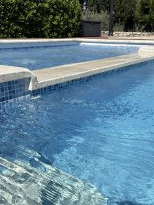 uma piscina com degraus na água em Le Mas Des Chutes em Graveson