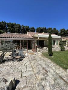 une maison avec une terrasse en pierre en face de celle-ci dans l'établissement Le Mas Des Chutes, à Graveson