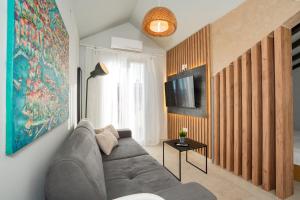 een woonkamer met een bank en een tv bij Residence Ellena in Zadar