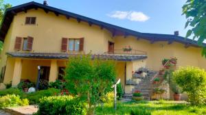 una casa amarilla con escaleras y flores en el patio en I Tre Lecci, en Nocera Umbra