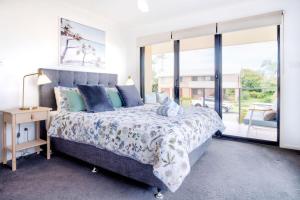 ein Schlafzimmer mit einem Bett und einem großen Fenster in der Unterkunft Stones Throw To Shelly Beach, Pet Friendly! in Caloundra