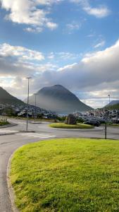 a view of a mountain with a city and a street at BRAND NEW FLAT IN CENTRAL KLAKSVÍK in Klaksvík