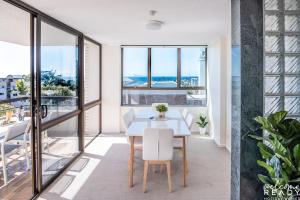 uma sala de jantar com uma mesa e vistas para o oceano em Retro Style Apartment Kings Beach with Ocean Views em Caloundra