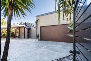 a house with a driveway and a garage at Pet Friendly House Opposite Bokarina Beach in Kawana Waters