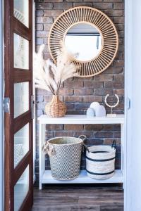 a shelf with baskets and a mirror on a brick wall at Pet Friendly House Opposite Bokarina Beach in Kawana Waters