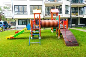 a playground in the grass in front of a building at ŁAJBA KAPITANA WYPOCZYNKOWA ROWY in Rowy