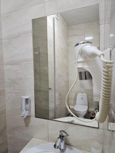 a bathroom with a mirror and a sink and a toilet at GRAND Hotel in Zatoka