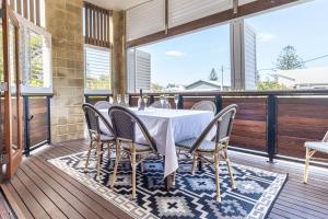 a dining table and chairs on a deck at Coastal Getaway Across From Dicky Beach in Caloundra