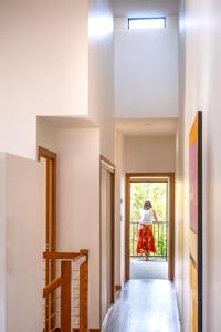 a woman walking down the hallway of a house at Coastal Getaway Across From Dicky Beach in Caloundra
