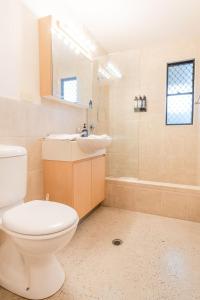 a bathroom with a toilet and a sink and a shower at Coastal Getaway Across From Dicky Beach in Caloundra