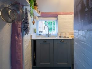 a kitchen with blue cabinets and a sink at Locke's Cottage in Alderminster
