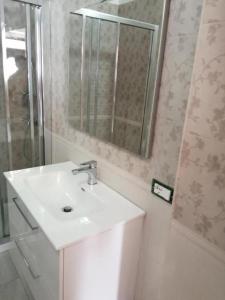 ein Badezimmer mit einem weißen Waschbecken und einem Spiegel in der Unterkunft Ke Rooms in Campomarino
