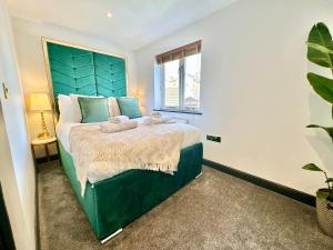 a bedroom with a large green bed with a window at 4 The Nest Central Ripon in Ripon