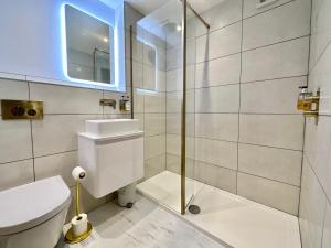 a bathroom with a toilet and a glass shower at 4 The Nest Central Ripon in Ripon