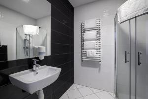 czarno-biała łazienka z umywalką i prysznicem w obiekcie Nova Stodola w mieście Kłomnice